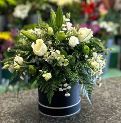 Harmony Hatbox - A luxurious hatbox arrangement featuring an elegant blend of crisp ivory, fresh green and lush foliage. Beautifully designed with varied textures and a timeless colour palette, this sophisticated display brings a sense of calm, grace and natural beauty. Presented in a stylish keepsake hatbox, it's a perfect gift for birthdays, anniversaries, sympathy, new beginnings or simply to show someone you care.