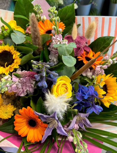 Sunset Meadow Bouquet - Bursting with warm, joyful tones and natural textures, the Sunset Meadow Bouquet is designed to bring a touch of countryside charm to any occasion. Wrapped in contemporary presentation and handcrafted with a vibrant mix of seasonal blooms, textured foliage, and soft natural accents, this bouquet creates a relaxed yet striking display. Perfect for birthdays, celebrations, thank you gifts, or simply brightening someone's day, each bouquet is thoughtfully arranged using the freshest flowers available, making every design beautifully unique.